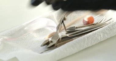 Kuaför salonundaki pedikür uzmanı, güzellik salonundaki ayak temizleme videosuyla ilgileniyor. Tırnaklarını törpülüyor. Siyah eldiven reklamında masaj yapıyor. Bir kadın videosunun hayatı.