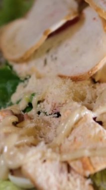 Pakette ahşap çatal bulunan tavuklu Sezar salatası ya da yemek servisi. Beslenme çantasında yemek. 4k video. Yüksek kalite 4k görüntü