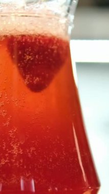 Açık büfe masasına yakın çekim, beyaz masa örtüsü ile ahşap masa örtüsü üzerinde soğuk taze komposto içeceği ve boş bardaklarla dolu cam sürahiler var. Görünür insan siluetleri. Yüksek kalite