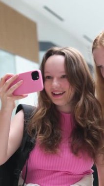 Mutlu kızlar, arkadaşlar, gençler, alışveriş merkezinde selfie çekiyorlar, yürüyorlar, iletişim kuruyorlar, birlikte zaman geçiriyorlar, sosyal ağlar kuruyorlar, internette fotoğraf paylaşıyorlar, uzun saçlarını gösteriyorlar. beyaz ten