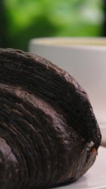 Sabah kahvaltısı ve öğle yemeği için aşırı yakın çekim. Sütlü, çıtır kruvasan ve sütlü bir fincan kahvenin dönüşümlü görüntüsü. Mükemmel sabah, günlük rutin. Sıcak bir atmosfer. Yüksek kalite 4k 