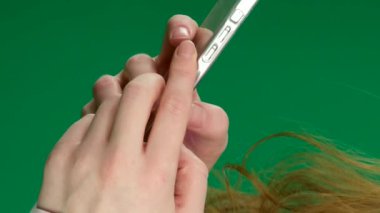 Üzerinde yeşil ekran olan bir akıllı telefonu mavi arka planda yükseltmek. Telefonun sadece elle çekilmiş görüntülerini kapat. Akıllı Telefon Kullanan Yüksek Kaliteli Kadın