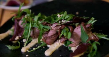 Çin bitkisel sosunda haşlanmış sığır eti dilimi. Parmesan soslu, sağlıklı, güzel yemek servisi yapan bir restoranda servis edilen kıvrılmış et ruloları. sığır dili dilimleme
