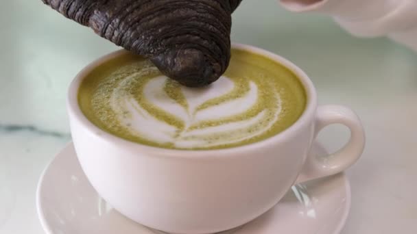 Siyah Bir Kruvasanı Köpüklü Sütlü Maço Yeşil Çayına Batırmak Lokantada — Stok video