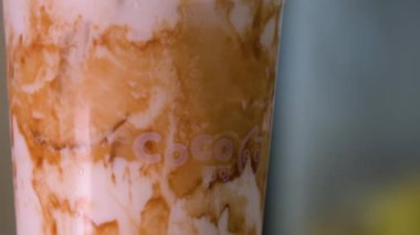 Kuromitsu siyah şeker şurubu ve beyaz arka planda Boba sıcak siyah inci, Tayvan içme kültürü ile köpüklü süt plastik bardak taze süt. Yüksek kalite 4k görüntü
