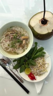 Vietnam 'da hindistan cevizi suyu kahvaltısı masasında geleneksel Vietnam pho çorbası yeşillik ve tavuk filizli fasulye filizleri kırmızı biber. Yüksek kalite 4k görüntü