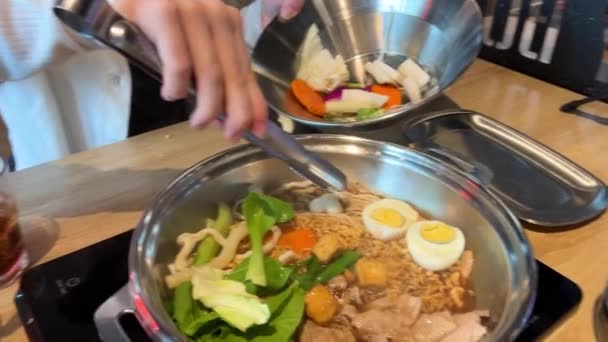 レストランで伝統的なベトナムスープを作り 独自の食材を選択し 鉄鍋に追加し ボウルでラーメンを回す麺で調理します 高品質の4K映像 — ストック動画