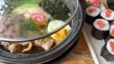 Asya erişte çorbası, tavuklu ramen, tofu, sebze ve siyah kasede yumurta. Geçmişi sil. Üst Manzara. Yüksek kalite 4k görüntü