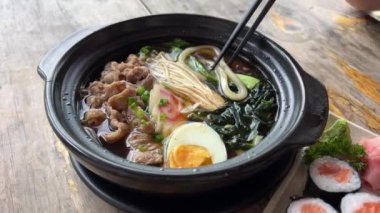 Asya erişte çorbası, tavuklu ramen, tofu, sebze ve siyah kasede yumurta. Geçmişi sil. Üst Manzara. Yüksek kalite 4k görüntü