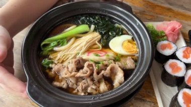 Asya erişte çorbası, tavuklu ramen, tofu, sebze ve siyah kasede yumurta. Geçmişi sil. Üst Manzara. Yüksek kalite 4k görüntü