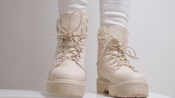 女性はトラクターソールの白いブーツで舌を引っ張り 保持します 近代的な秋の靴を模したモデル 高品質の4K映像 — ストック動画