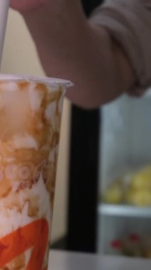 Kuromitsu siyah şeker şurubu ve beyaz arka planda Boba sıcak siyah inci, Tayvan içme kültürü ile köpüklü süt plastik bardak taze süt. Yüksek kalite 4k görüntü