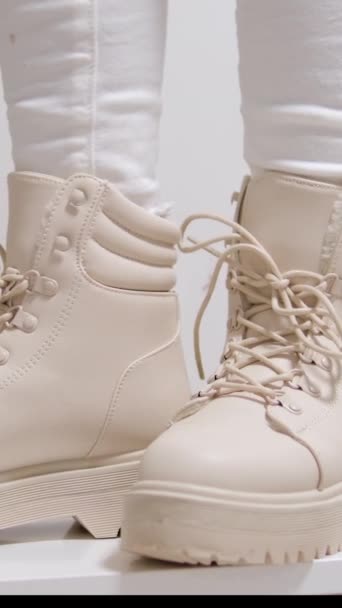 雌性在拖鞋鞋底的白色靴子处拉扯并握住舌头 展示现代秋鞋的模型 高质量的4K镜头 — 图库视频影像