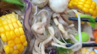 Tayland 'ın orta kesimindeki yerel yüzen markette erişte yapmak çok ünlü bir turistin gelip Kore yemeklerini yemesini sağlıyor. Yemek masası.