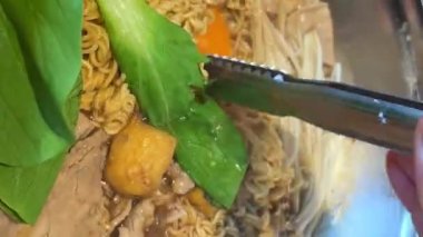 Tayland 'ın orta kesimindeki yerel yüzen markette erişte yapmak çok ünlü bir turistin gelip Kore yemeklerini yemesini sağlıyor. Yemek masası.