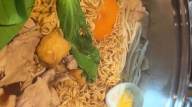 Tayland 'ın orta kesimindeki yerel yüzen markette erişte yapmak çok ünlü bir turistin gelip Kore yemeklerini yemesini sağlıyor. Yemek masası.