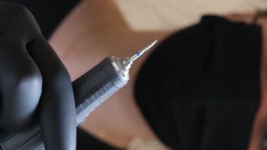Kuaför salonundaki pedikür uzmanı, güzellik salonundaki ayak temizleme videosuyla ilgileniyor. Tırnaklarını törpülüyor. Siyah eldiven reklamında masaj yapıyor. Bir kadın videosunun hayatı.