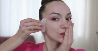 Yüzüne masaj yapan, yüzünü serinleten buz küresi yapan bir kadın. Slim Chin ve Neck 'te parmak izi var. Yüz masajı ve estetik cerrahi. Yüksek kalite