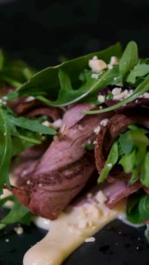 Çin bitkisel sosunda haşlanmış sığır eti dilimi. Parmesan soslu, sağlıklı, güzel yemek servisi yapan bir restoranda servis edilen kıvrılmış et ruloları. sığır dili dilimleme