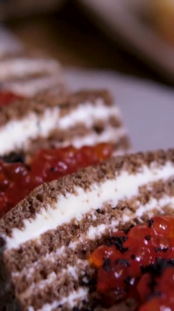 ブラックパンに赤いキャビアとバター レストランのパーチペーパーにケーキの形で黒いパンを塗ったサンドイッチ おいしい 美しい黒と赤のキャビアを皿の上に提供します 高品質で — ストック動画