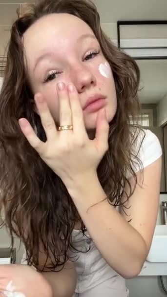 Ένα Νεαρό Έφηβο Κορίτσι Εφαρμόζει Αντηλιακό Ένα Λευκό Πρόσωπο Κοντά — Αρχείο Βίντεο