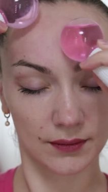 Yüzüne masaj yapan, yüzünü serinleten buz küresi yapan bir kadın. Slim Chin ve Neck 'te parmak izi var. Yüz masajı ve estetik cerrahi. yüz ve vücut için cryosfra