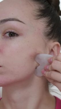 Yüzüne masaj yapan, yüzünü serinleten buz küresi yapan bir kadın. Slim Chin ve Neck 'te parmak izi var. Yüz masajı ve estetik cerrahi. Yüksek kalite