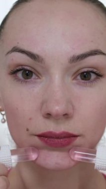 Yüzüne masaj yapan, yüzünü serinleten buz küresi yapan bir kadın. Slim Chin ve Neck 'te parmak izi var. Yüz masajı ve estetik cerrahi. Yüksek kalite