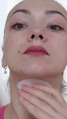 Yüzüne masaj yapan, yüzünü serinleten buz küresi yapan bir kadın. Slim Chin ve Neck 'te parmak izi var. Yüz masajı ve estetik cerrahi. Yüksek kalite
