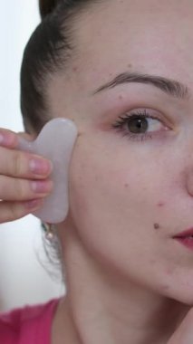 Yüzüne masaj yapan, yüzünü serinleten buz küresi yapan bir kadın. Slim Chin ve Neck 'te parmak izi var. Yüz masajı ve estetik cerrahi. Yüksek kalite