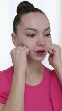 Jimnastik yapan kadın yüzüne masaj yapıyor yüz soğutucu buz küresi. Slim Chin ve Neck 'te parmak izi var. Yüz masajı ve estetik cerrahi. Yüksek kalite