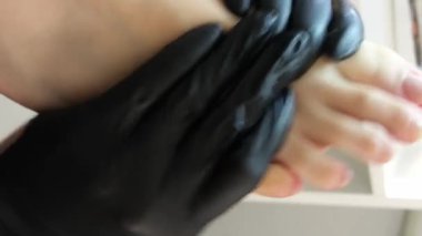 Manikür ve pedikür yapan kadın pedikür yapmadan önce manikür makinesiyle müşterilerinin tırnaklarındaki jöle kabuk cilasını temizler. Güzellik uzmanı eski verniği manikür makinesiyle çıkarıyor. Jölenin çıkarılması. 