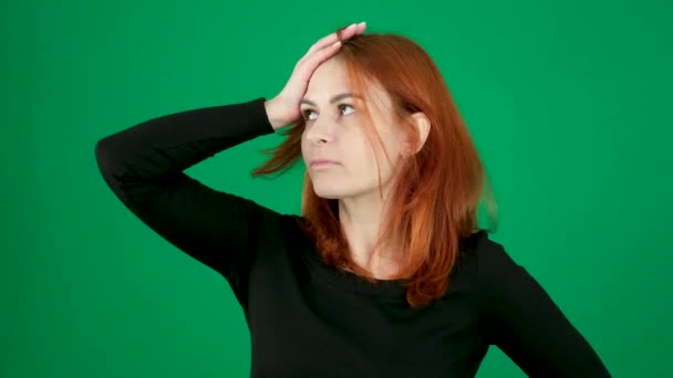 思慮深い表情の興奮を持つ少女のビデオ 頭の垂直ビデオを手で クロマキースタジオの緑の背景にある赤い髪の若い女性は ブラウンの目を閉じる感情 — ストック動画