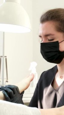 Manikür ve pedikür yapan kadın pedikür yapmadan önce manikür makinesiyle müşterilerinin tırnaklarındaki jöle kabuk cilasını temizler. Güzellik uzmanı eski verniği manikür makinesiyle çıkarıyor. Jölenin çıkarılması. 