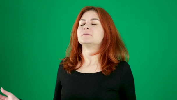 赤毛の少女は 手を挙げた 折られた指と緑色の背景赤い髪の若い女性のクロマキースタジオの感情ライトスキンヨーロッパのアメリカ人で目を閉じた願いを作る瞑想します カナダ — ストック動画