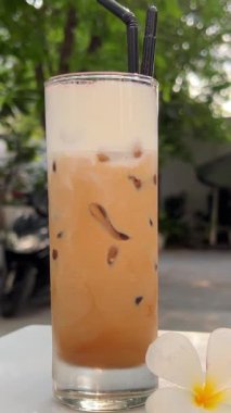 Yazın deniz kenarında nefis buzlu latte kahve. Sahildeki kafede soğuk bir şeyler içelim. Seyahat et ve Bali adasının tadını çıkar. Bardakta yüksek kaliteli buzlu latte kahve.