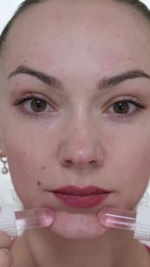 Yüzüne masaj yapan, yüzünü serinleten buz küresi yapan bir kadın. Slim Chin ve Neck 'te parmak izi var. Yüz masajı ve estetik cerrahi. Yüksek kalite