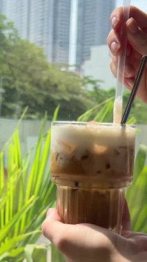 Geleneksel Vietnam kahvesi, pencerenin arka planında tuzlu beyaz kaşık köpüklü yoğun sütlü sütlü sütlü latte ile karıştırılır. Yüksek kalite 4k görüntü