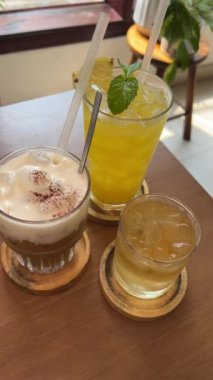 Masada üç farklı içecek. Sağlıklı yiyecek suyu. Ananas suyu. Tuzlu karamelli Latte, tuzlu yeşil çay ve karabuğday çayı. Yüksek kalite