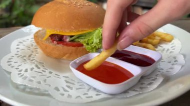 Küçük kız bir fast food restoranında patates kızartması yiyor. Yüksek kalite 4k görüntü