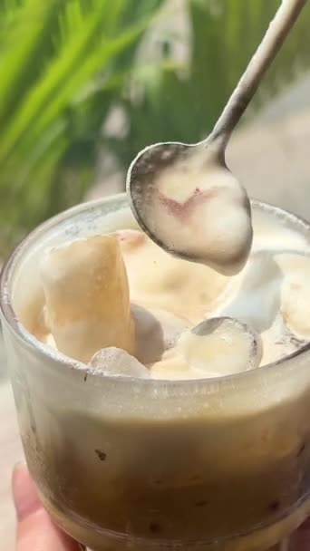 窓の背景に塩が付いた伝統的なベトナムのコーヒーは スプーン厚い白い泡でおいしい多くの凝縮ミルク甘いコーヒーラテ 高品質の4K映像 — ストック動画