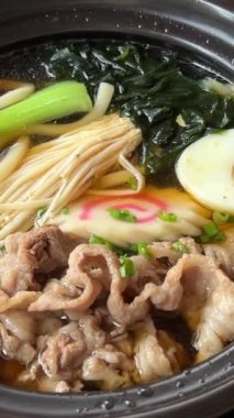 Asya erişte çorbası, tavuklu ramen, tofu, sebze ve siyah kasede yumurta. Geçmişi sil. Üst Manzara. Yüksek kalite 4k görüntü
