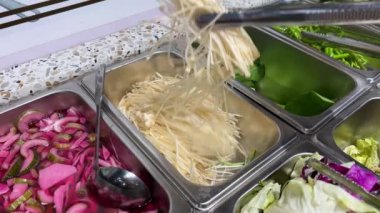 Tayland 'ın orta kesimindeki yerel yüzen markette erişte yapmak çok ünlü bir turistin gelip Kore yemeklerini yemesini sağlıyor. Yemek masası.