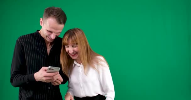 男人和女人手持平板手机在绿色背景下聊天在办公室举行会议学习如何处理网上调情关系调情 夫妻解决的问题 — 图库视频影像
