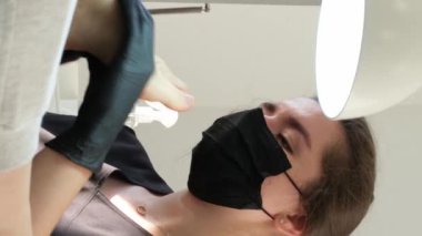 Manikür ve pedikür yapan kadın pedikür yapmadan önce manikür makinesiyle müşterilerinin tırnaklarındaki jöle kabuk cilasını temizler. Güzellik uzmanı eski verniği manikür makinesiyle çıkarıyor. Jölenin çıkarılması. 