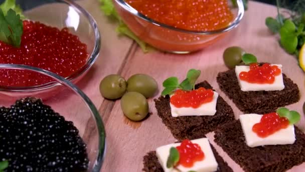 白とボロディーノのパンに赤と黒のキャビアが付いているサンドイッチ 高品質の4K映像 — ストック動画