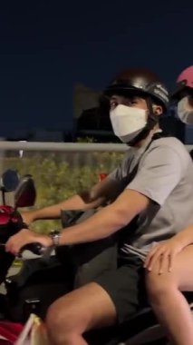 Yılbaşı kutlamasından bir gece önce, sokakta motosikletli Saigon İnsanları Tet. Vietnam Ho Chi Minh Şehri 02.07.2024