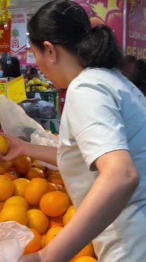 Tet Vietnam insanları süpermarketten bir sürü kalabalık maskesi alırlar. Aile için yeni yıl tatili için çiçek ve hediyelerle dolu bir sürü insan sırada bekliyor. 02.08.2024.