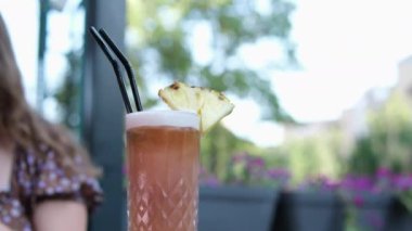 Cep telefonuyla konuşan, sağlıklı organik meyve sularını karıştıran, pipet kullanan, hafta sonlarını dışarıda geçiren, rahat bir kafede dinlenen bir kadın. çürümüş, tatsız