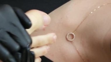 Masör kaplıcadaki sıcak taşlarla ayak masajı yapıyor. Adam volkanik taşı elinde tutuyor ve güçlü bir şekilde hassas müşteri bacakları sürterek yumuşak havluya uzanıyor. Tecrübeli usta işi.